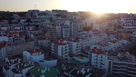 Morning-lights-over-residential-buildings,-Ericeira-downtown-with-sunbeam-peeking-through-cityscape