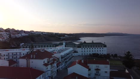 Luftaufnahme-Der-Küste-Von-Ericeira-Bei-Sonnenaufgang,-Hotelgebäude-Am-Meer,-Portugal