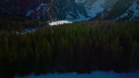 Ein-Flug-über-Fichten-Zeigt-Den-Zugefrorenen-Pragser-Wildsee-In-Den-Dolomiten,-Italien