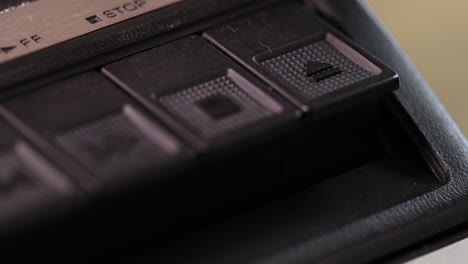 Eject-button-on-an-old-vintage-cassette-player-being-pressed-macro
