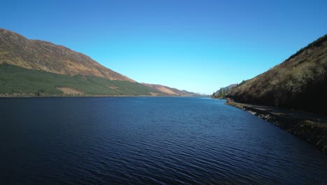 Flying-over-traveller-on-lake-shore-at-Loch-Lochy-Scottish-Highlands