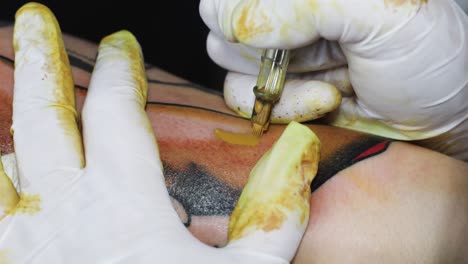 Tattoo-machine-needles-penetrating-skin,-sperm-whale-tattoo