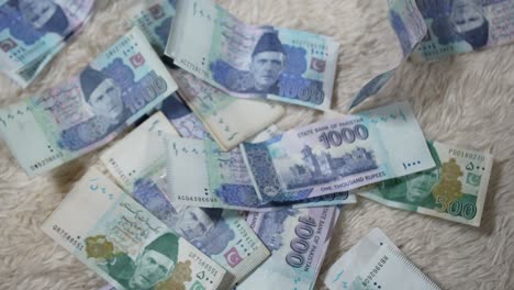 Pakistanische-Banknoten-Fallen-Auf-Den-Boden-–-Nahaufnahme-Der-Fallenden-1000--Und-500-PKR-Banknoten