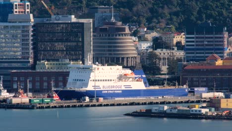 Bluebridge-passenger-ferry-moored-in-capital-Wellington,-New-Zealand-Aotearoa-with-city-landscape-view-of-Parliamentary-Beehive-and-CBD-buildings