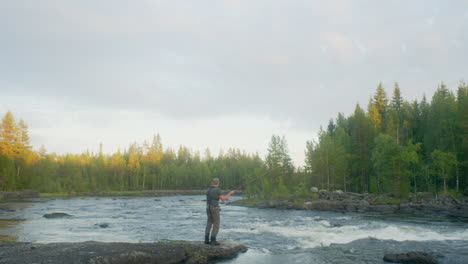 Fly-fisherman-casting-with-his-fly-rod-in-the-rapids-during-a-summer-night
