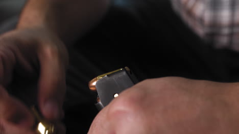 Man-Loading-ammo-in-to-a-pistol-magazine-in-slow-motion