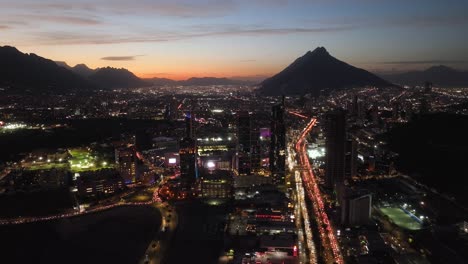Night-lit-skyline-of-San-Pedro-Garza-Garcia,-Monterrey,-dusk-in-Mexico---Aerial-view