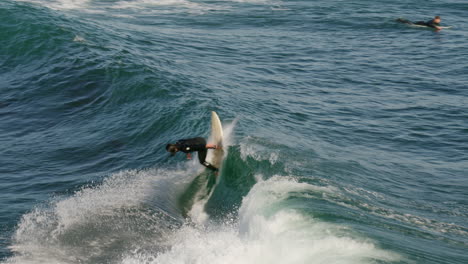 Surfer-makes-a-turn-on-surfboard-in-Santa-Cruz,-CA