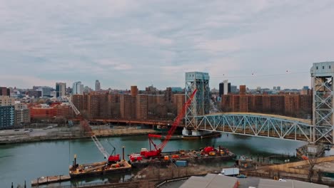 Slow-push-with-4K-drone-of-bridge,-East-River,-in-New-York-city,-buildings-in-background