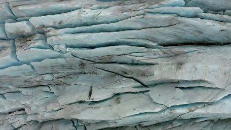 Aerial:-Rising-top-down-view-of-jagged-ice-surface-of-frozen-glacier