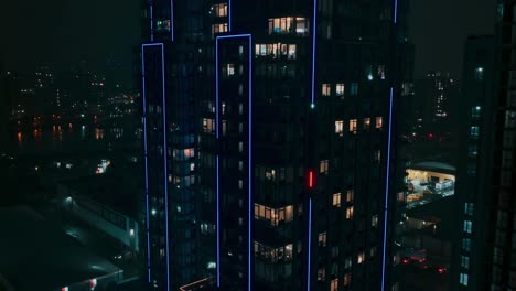Slow-shot-approaching-high-rise-building,-luxury-apartments,-night