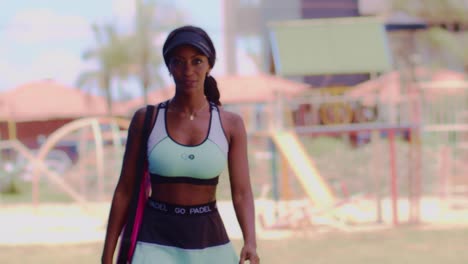 Sexy-latin-woman-with-padel-sportswear-smiling-and-walking-towards-camera-in-slow-motion