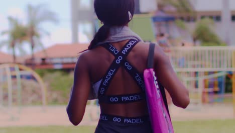 Athletic-woman-in-paddle-clothes-walking-with-her-back-to-the-camera-in-slow-motion