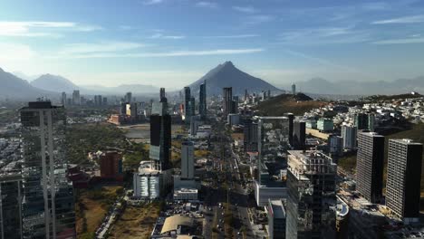 Aerial-view-through-skyscrapers-and-over-the-highway-85-in-sunny-San-Pedro-Garza-Garcia,-Monterrey,-Mexico