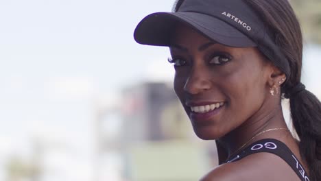 Slow-motion-close-up-of-portrait-of-black-attractive-woman-smiling-with-sporty-padel-cap