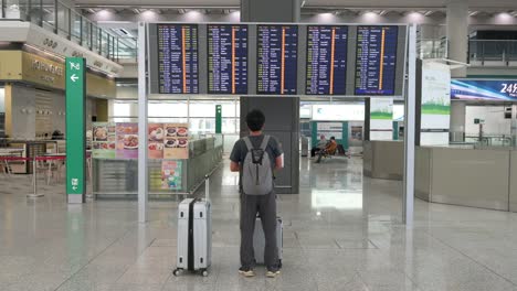 A-passenger-looks-at-a-flight-information-screen-where-airline-check-in-desks-are-located-in-Hong-Kong's-international-airport