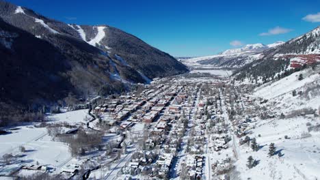 Drone-flying-into-Telluride,-Colorado-on-a-clear-sunny-day-in-winter