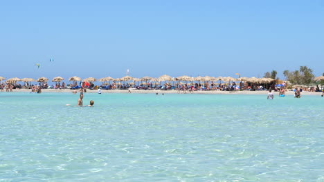 Strand-Voller-Sonnenschirme-Und-Touristen-In-Den-Gewässern-Des-Strandes-Von-Elafonissi,-Kreta