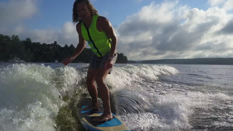 Young-Caucasian-man-surfs-on-breaking-wake-wave-behind-motorboat