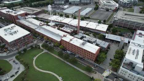 Aerial-drone-tilts-up-at-American-Tobacco-campus-in-Durham,-NC