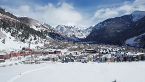Panning-drone-shot-showing-all-of-Telluride,-Colorado-with-mountains-in-distance