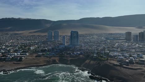 Aerial-hyper-lapse-shot-along-the-ocean-of-downtown-Iquique,-Chile