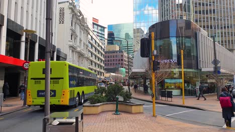 Popular-Lambton-Quay-in-central-business-district-of-capital-city-Wellington-in-New-Zealand-Aotearoa-during-busy-lunchtime-with-people-walking-around-retail-shops,-offices,-with-buses-and-traffic
