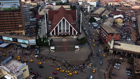 Aerial-view-in-front-of-the-Cathedral-of-Our-Lady-of-Victories-in-Yaounde,-Cameroon---descending,-tilt,-drone-shot