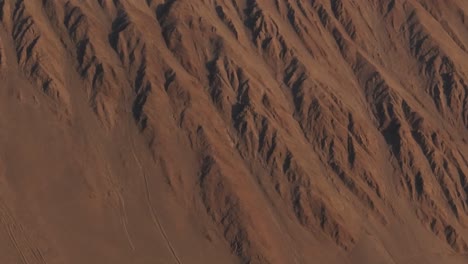 Aerial-dolly-shot-of-the-uneven-terrain-on-the-side-of-a-large-mountain-in-Iquique,-Chile