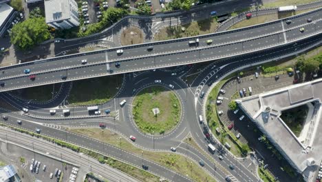 Descending-aerial-top-down-shot-of-traffic-on-highway-and-roundabout-during-sunny-day---Vacoas-Phoenix,-Mauritius