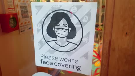 Face-mask-poster-sign-on-retail-store-front-door-during-COVID-pandemic-in-New-Zealand-Aotearoa