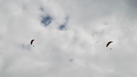 Looking-up-at-two-paragliders,-Queenstown-New-Zealand