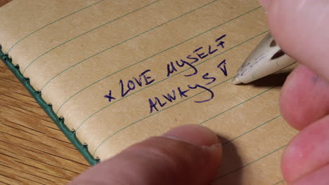 Writing-self-love-note-on-notebook-paper,-macro-close-up-view