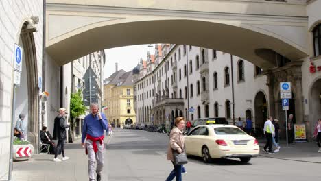 Busy-people-walk-by-on-a-street-under-a-bridge-in-the-downtown-center-of-Vienna-Austria