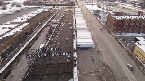Produce-terminal-in-Detroit-city-during-winter-season,-aerial-ascend-view