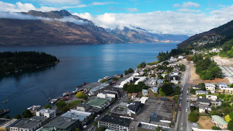 aerial-scenic-view-of-Queenstown,-New-Zealand,-on-the-shores-of-the-South-Island’s-Lake-Wakatipu-with-amazing-mountains-landscape-during-a-sunny-day-of-summer