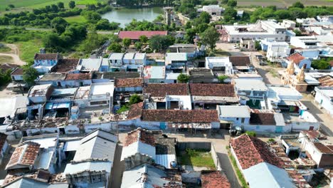 Small-indian-village-drone-shot,-with-old-houses-and-temple-with-lake,-rural-India,-country-side