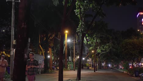 Park-goers-strolling-at-night-in-a-park-in-Ho-Chi-Minh-City,-Vietnam
