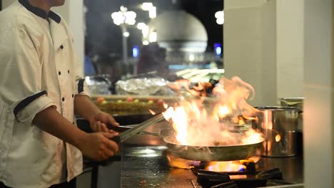 Chef-Preparando-Comida-En-Una-Cacerola-En-La-Estufa-De-Gas-De-La-Cocina-De-Un-Restaurante