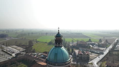 Aerial-drone-shot-over-a-bell-tower-in-a-village-in-the-Caravaggio-sanctuary,-Lombardy