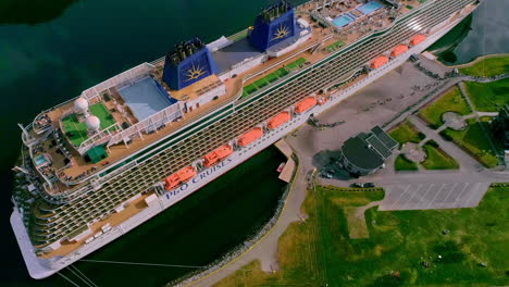 Drone-shot-of-tourism-getting-embarking-a-giant-cruise-ship-on-a-sunny-day