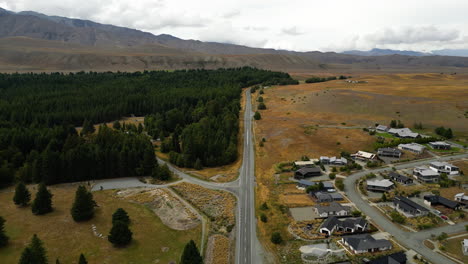 Countryside-road-leading-through-small-village-of-New-Zealand,-aerial-drone-view