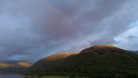 4k-aerial-drone-footage-of-rainbow-at-sunset-above-mountains-in-scottish-highlands-scotland