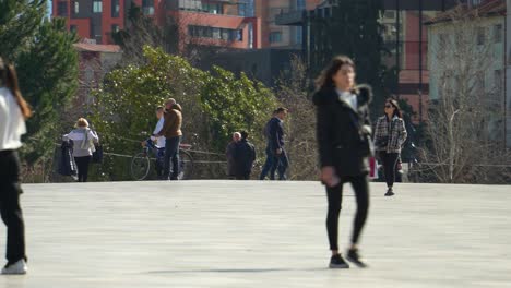 People-walking-from-different-directions-on-main-square-of-Tirana-capital-city-in-Albania
