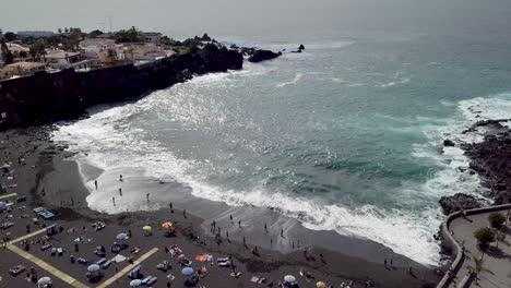 drone-fly-above-playa-de-la-arena-crowded-with-tourist-during-holiday-,-aerial-footage-of-Tenerife-island