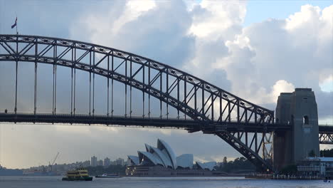 A-ferry-passes-by-Sydney-Harbour-Bridge-in-the-morning,-Australia