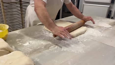 Artisan-baker-rolling-out-pastry-puff-in-his-workshop