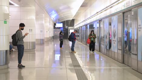 Commuters-wait-for-an-airport-train-to-arrive-at-an-underground-station-in-Hong-Kong