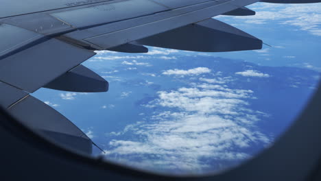 view-out-of-flight-passenger-window-over-a-sea-of-cloud-and-airplane-wings