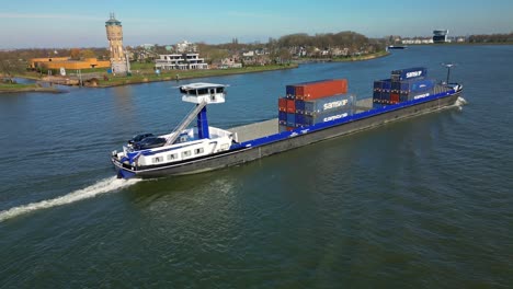 Aerial-view:-Transportation-ship-with-containers-and-cars-moving-past-"De-Oude-Maas"-Canal-in-Dordrecht-the-Netherlands